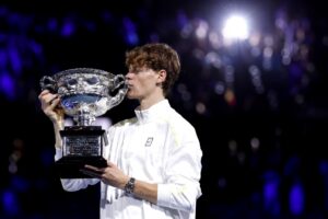 Jannik Sinner comemorando conquista do Australian Open com beijo no trofu (foto: Martin Keep/AFP)