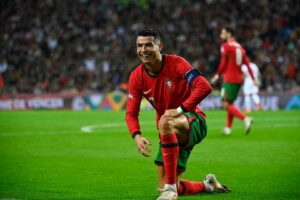 Cristiano Ronaldo agachado comemorando gol de Portugal (foto: Miguel Riopa/AFP)