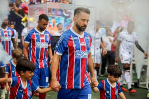 Everton Ribeiro entrando em campo de mos dadas com duas crianas (foto: Tiago Caldas /EC Bahia)