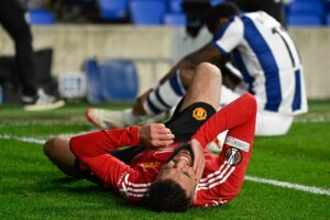 Jogador do United, Noussair Mazraoui, deitado em campo (foto: Ander Gillenea / AFP)