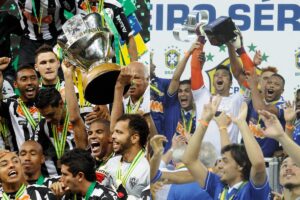Jogadores de Atltico e Cruzeiro, respectivamente, comemoram os ttulos da Copa do Brasil e Campeonato Brasileiro (foto: Washington Alves/Reuters - 	27/11/2014  |  Ramon Lisboa/EM/D.A Press - 	1/12/2013)