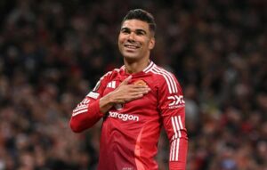 Casemiro com mo sobre escudo do united (foto: Oli Scarff / AFP)
