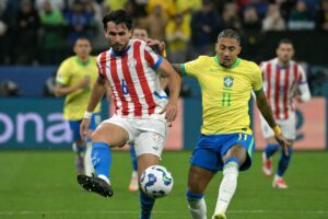 Alonso, do Atltico, divide bola com Raphinha durante Brasil x Paraguai (foto: NELSON ALMEIDA / AFP)