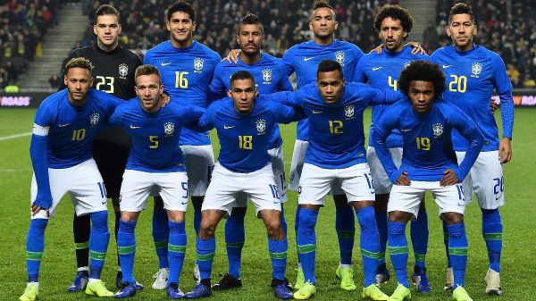 Neymar e Arthur Melo (abaixados,  esquerda) perfilados com a Seleo para amistoso em 2018 (foto: Glyn Kirk/AFP)